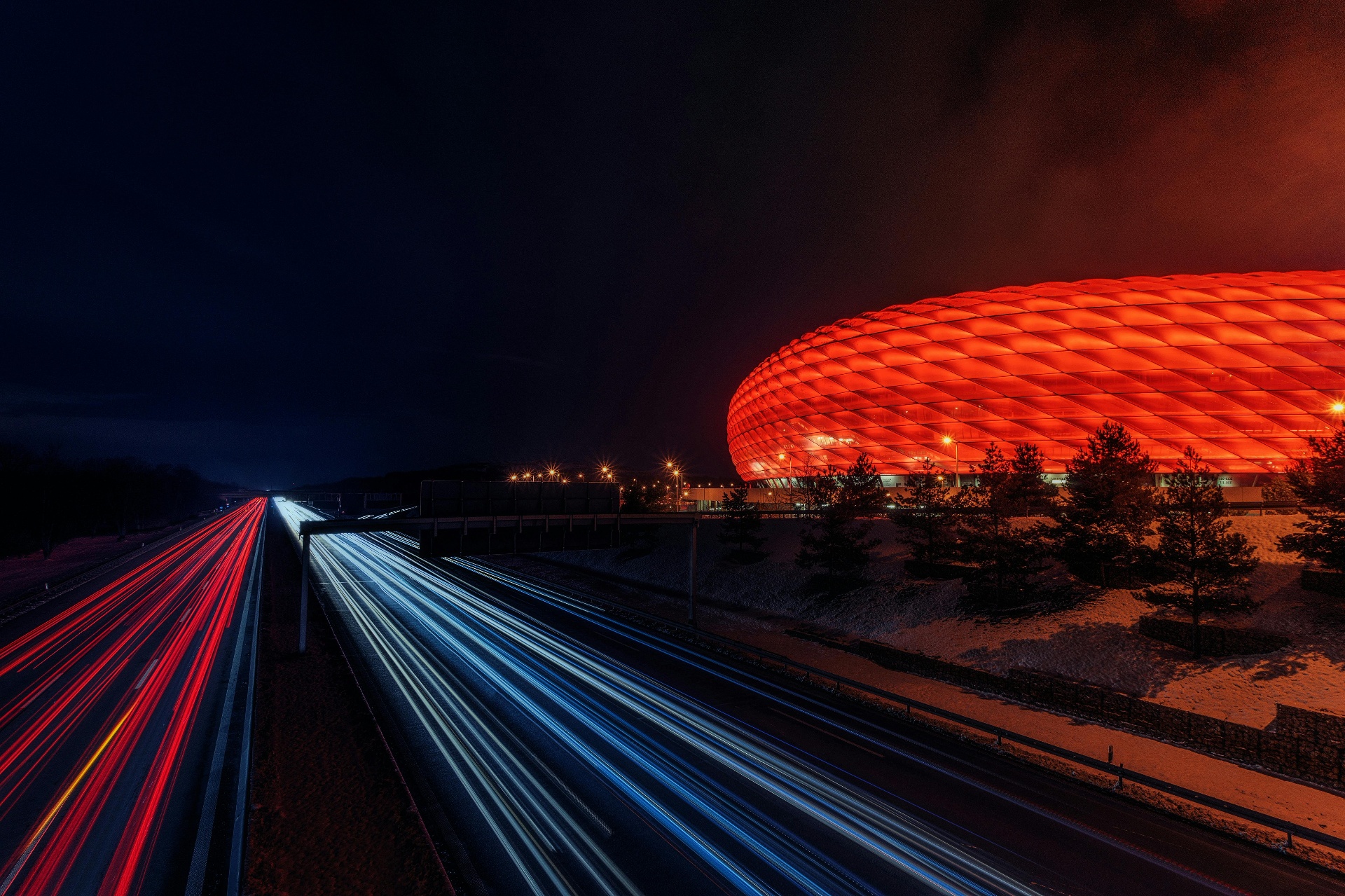 Über uns – Gewerbefläche mieten 2026: Moderne Gewerbearchitektur bei Nacht mit beleuchteten Verkehrswegen in Deutschland